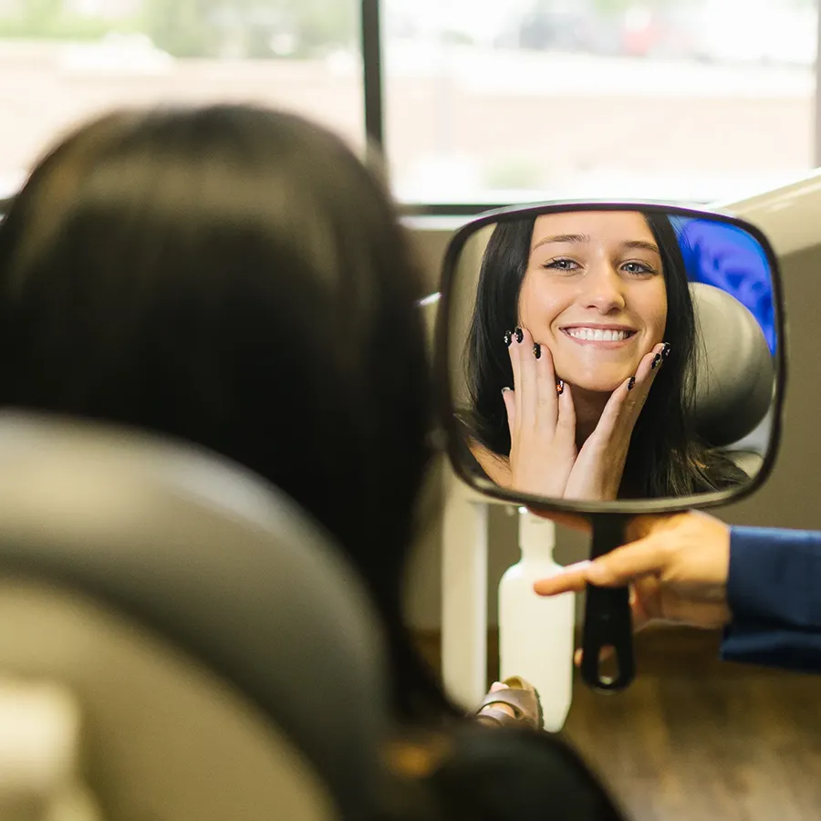 Real Patient Admiring Her New Veneers In Mirror