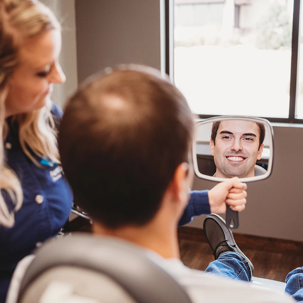 Bismarck Cosmetic Dentistry Patient Smiling in Mirror